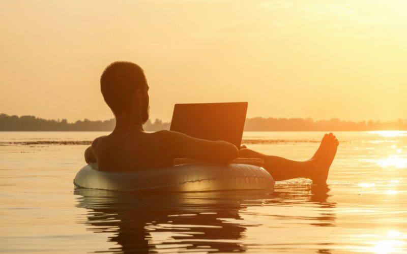 Een man die in het water ligt met zonsondergang.