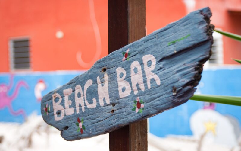 Een bordje beach bar op een strand.