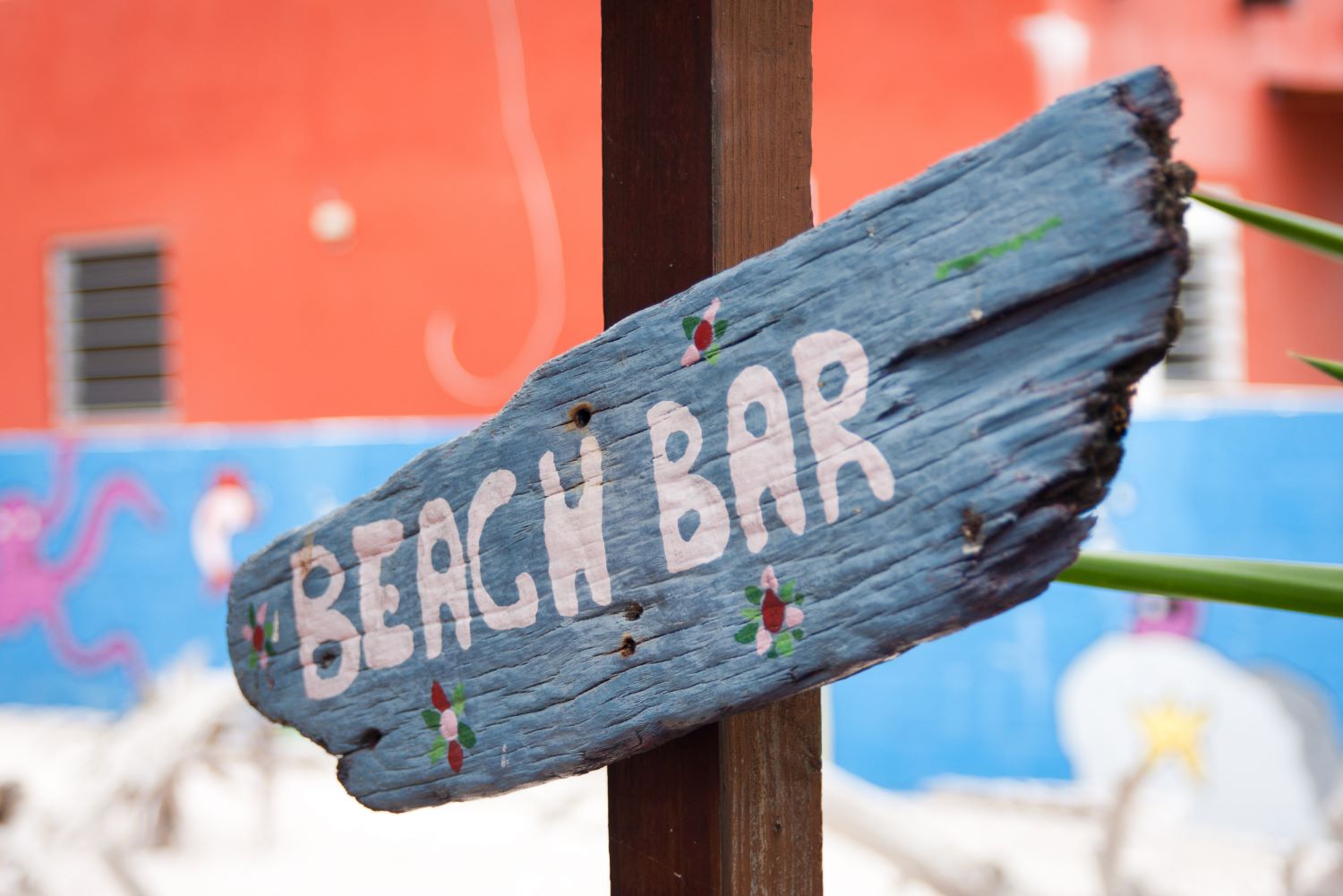Een bordje beach bar op een strand.