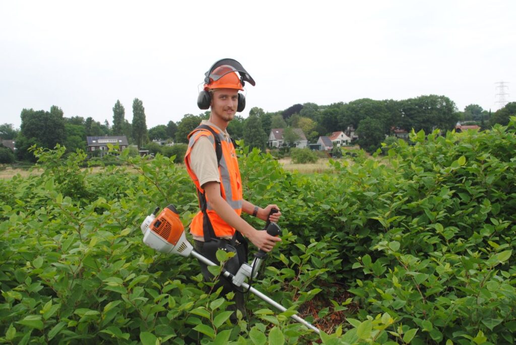 een man is aan het bos-maaien.