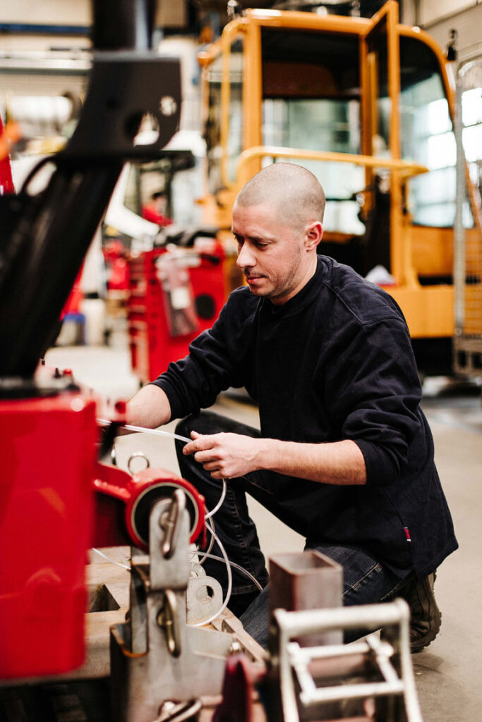 Een man is aan het sleutelen aan een apparaat.