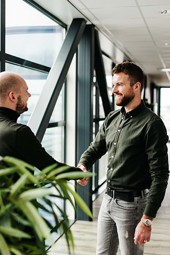 2 mannen geven elkaar een handdruk na een sollicitatiegesprek.