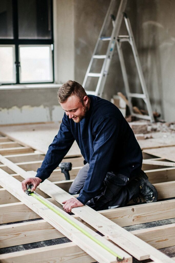 Een timmerman is een houten constructie aan het bouwen.