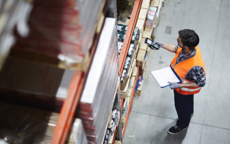 logistiek medewerker bezig met het scannen van de producten in de schappen.