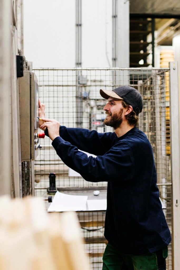 Een man die in de productie werkt. Hij is in zijn werkplaats bezig.