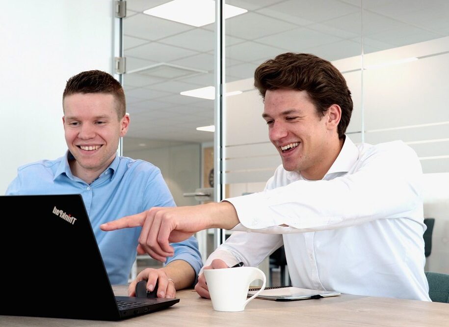 2 recruiters die samen bezig zijn op een laptop.