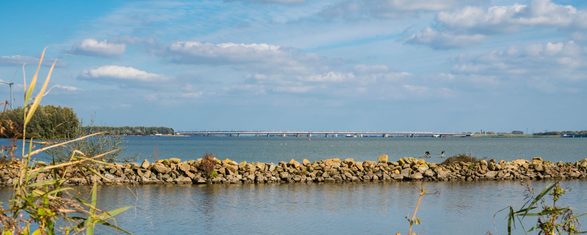 De moerdijkbrug op verre afstand vanuit het water bellicht.