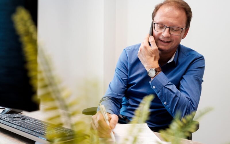 Een recruiter van Intro Personeel die druk bezig is met het verwerken van een telefonische sollicitant die op zoek is naar de juiste functie.