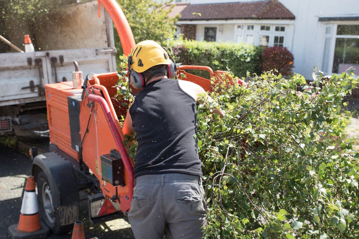 Een hovenier druk aan het werk in de buitenlucht.