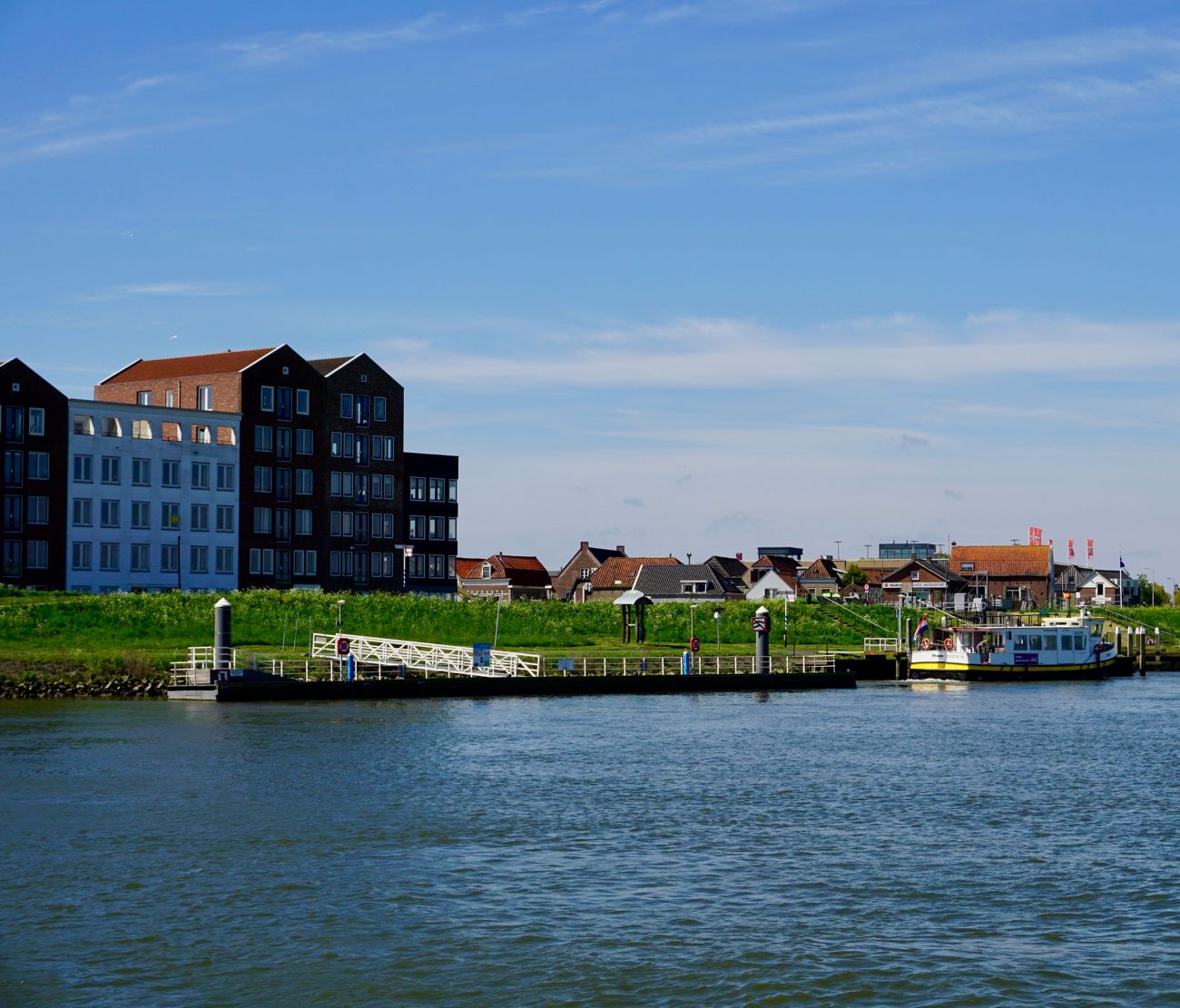 Water en huisjes in de Hoeksche waard langs een rivier.