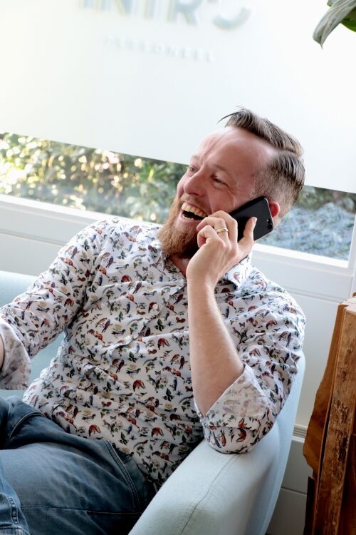 Een man, een recruiter, aan het bellen en aan het lachen