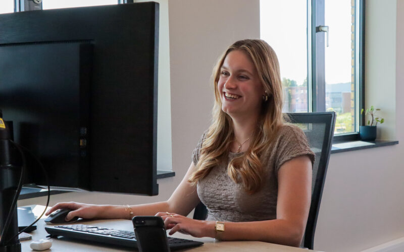 Joelle van Intro Personeel lacht naar haar computer beeldscherm