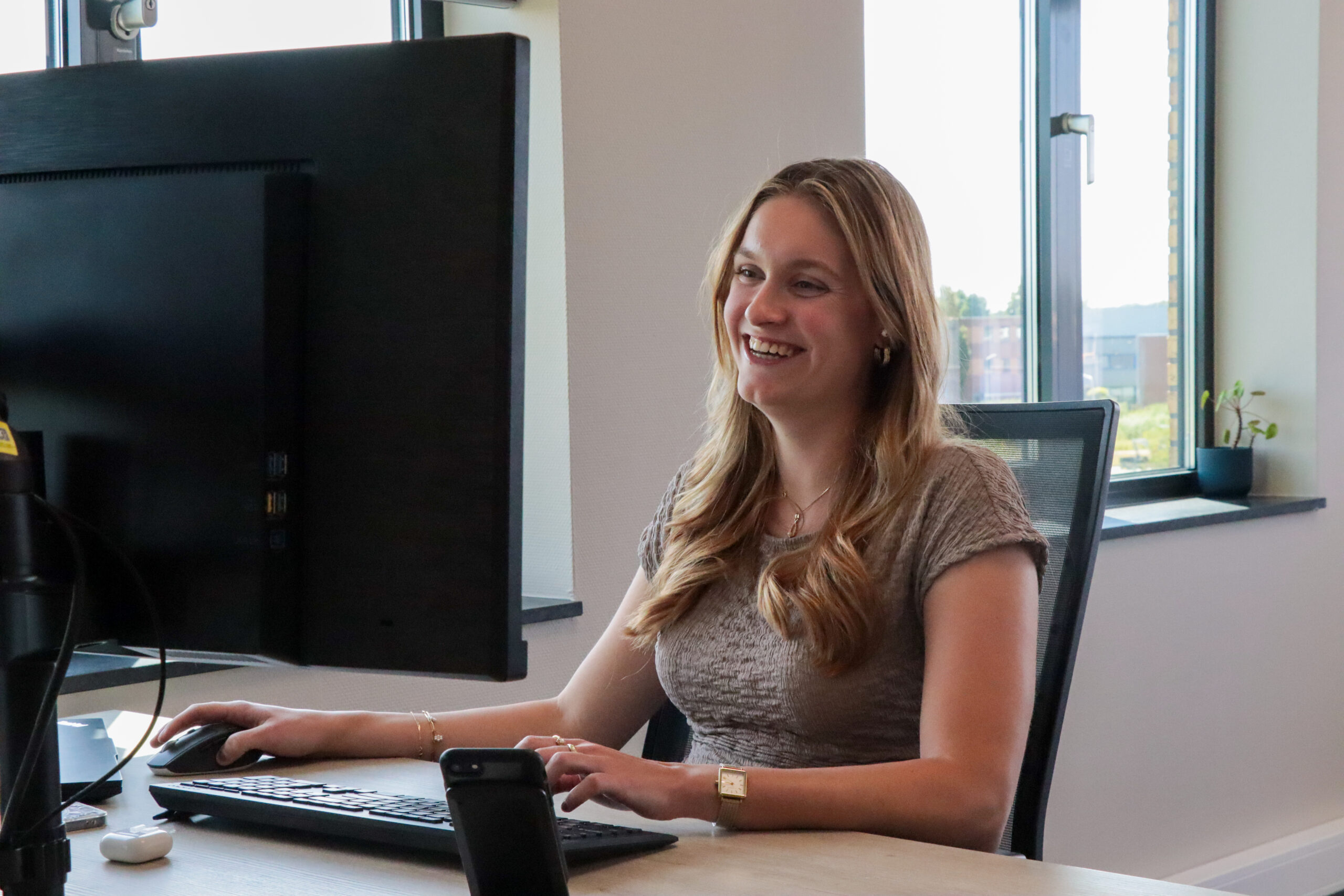 Joelle van Intro Personeel lacht naar haar computer beeldscherm